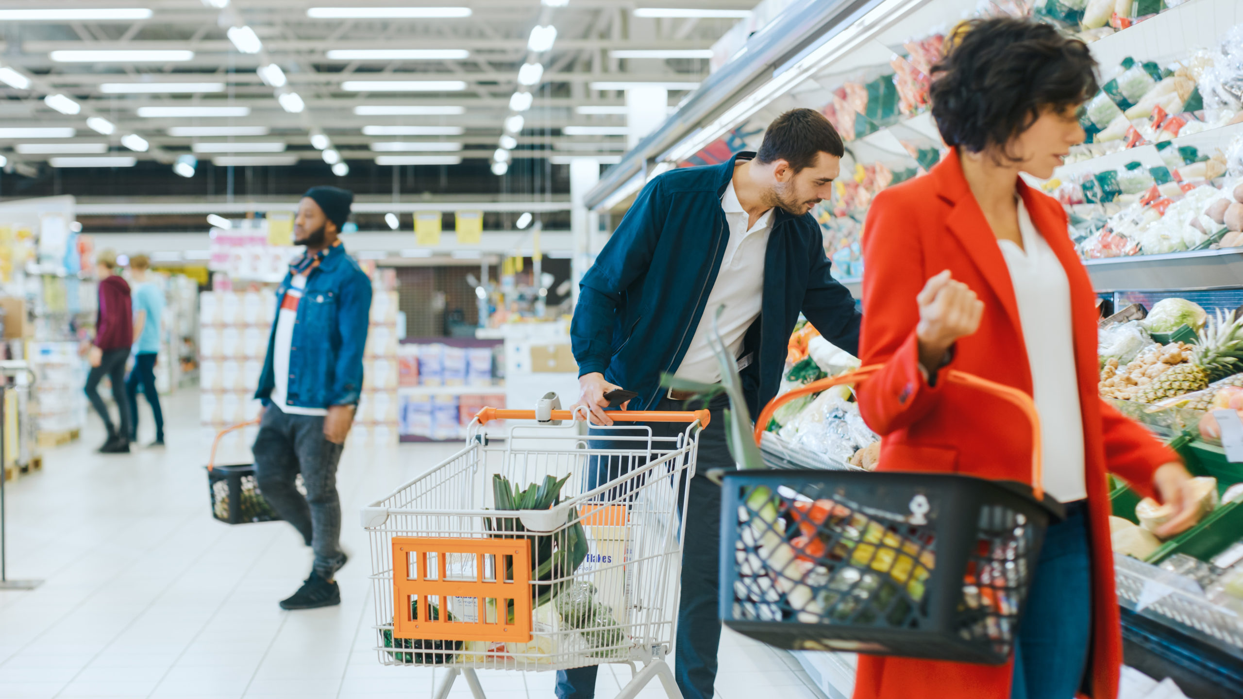 At the Supermarket: Handsome Man with Smartphone, Pushes Shopping cart