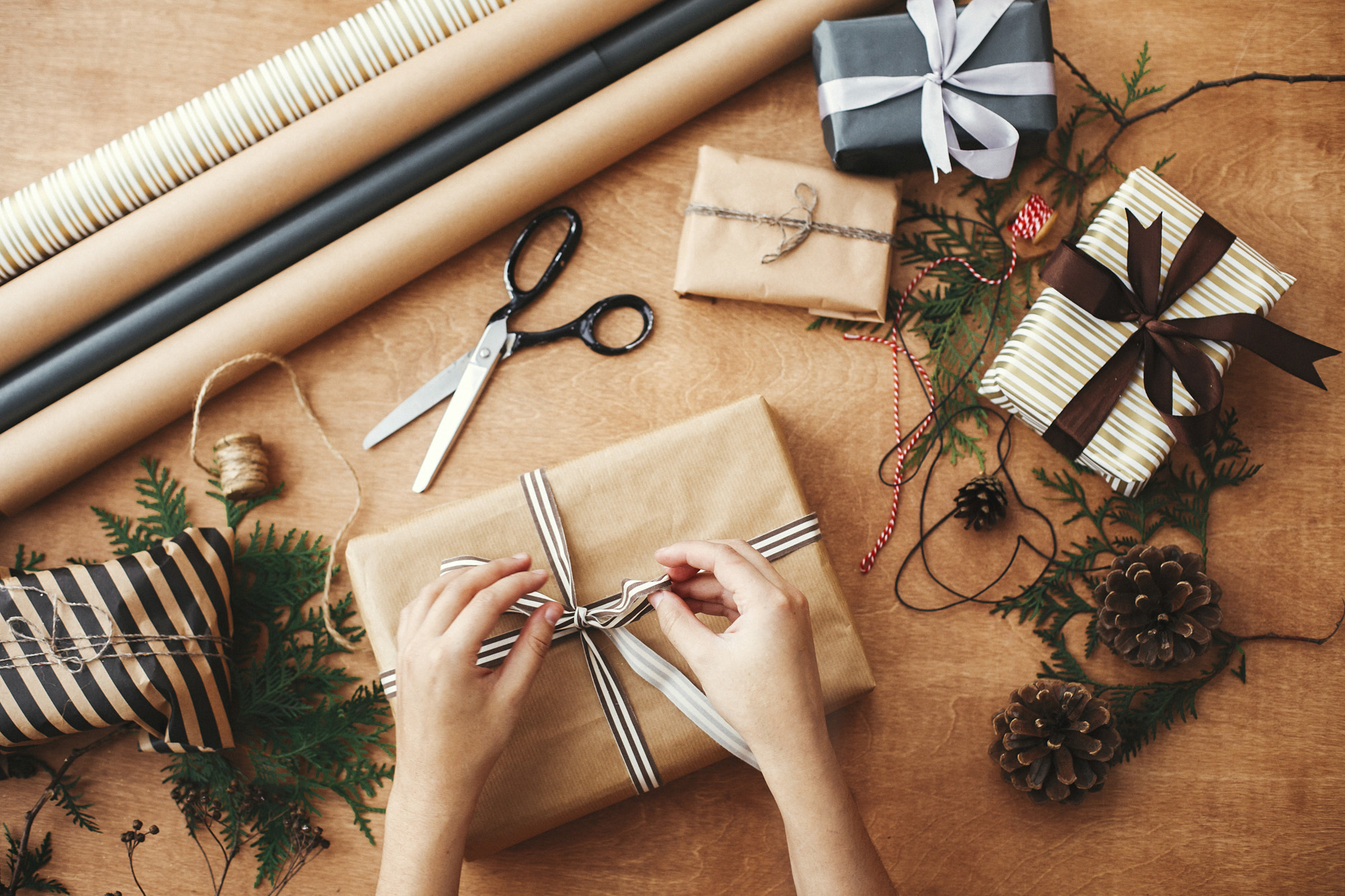 Hands wrapping stylish christmas gift