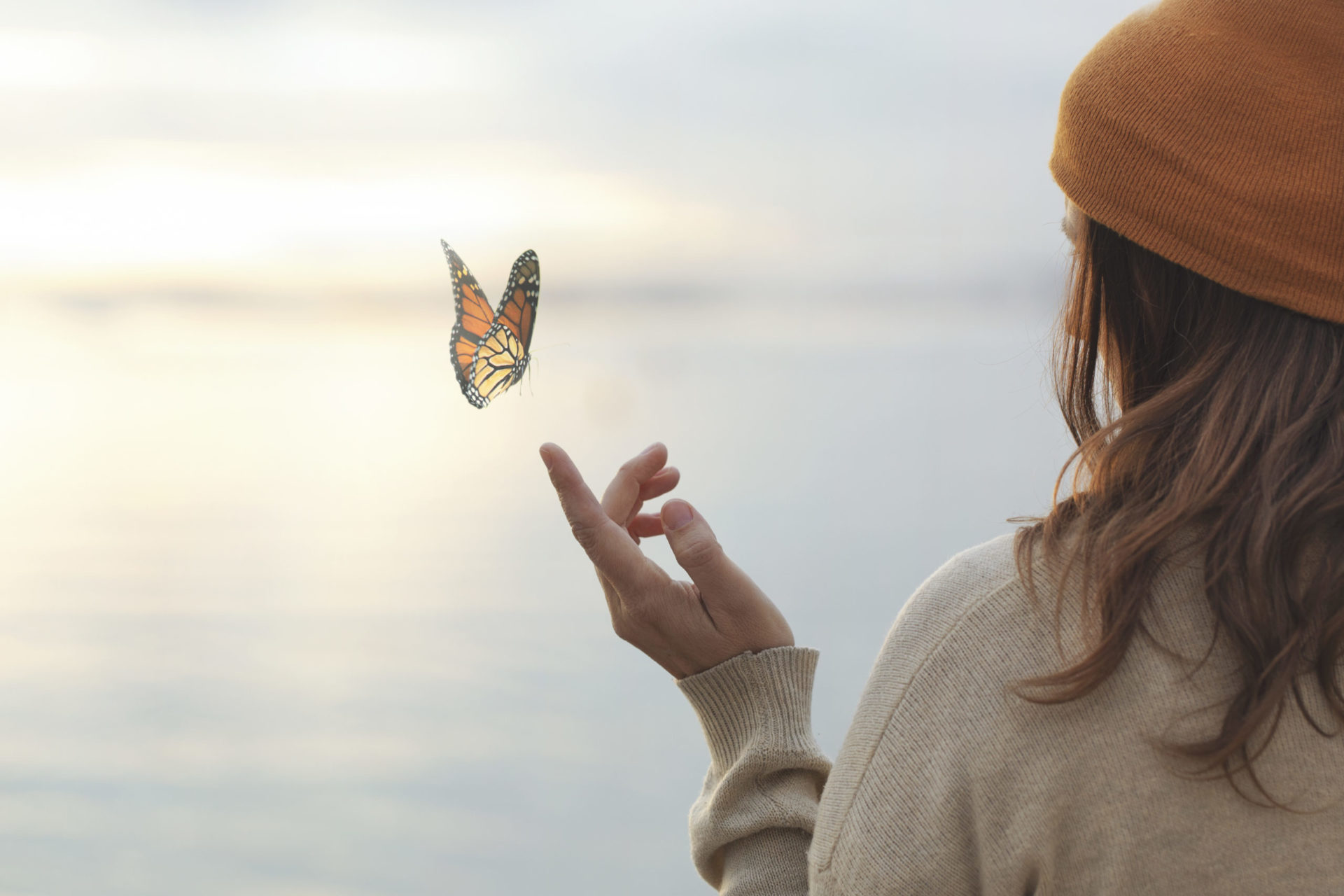 colorful butterfly is laying on a woman's hand