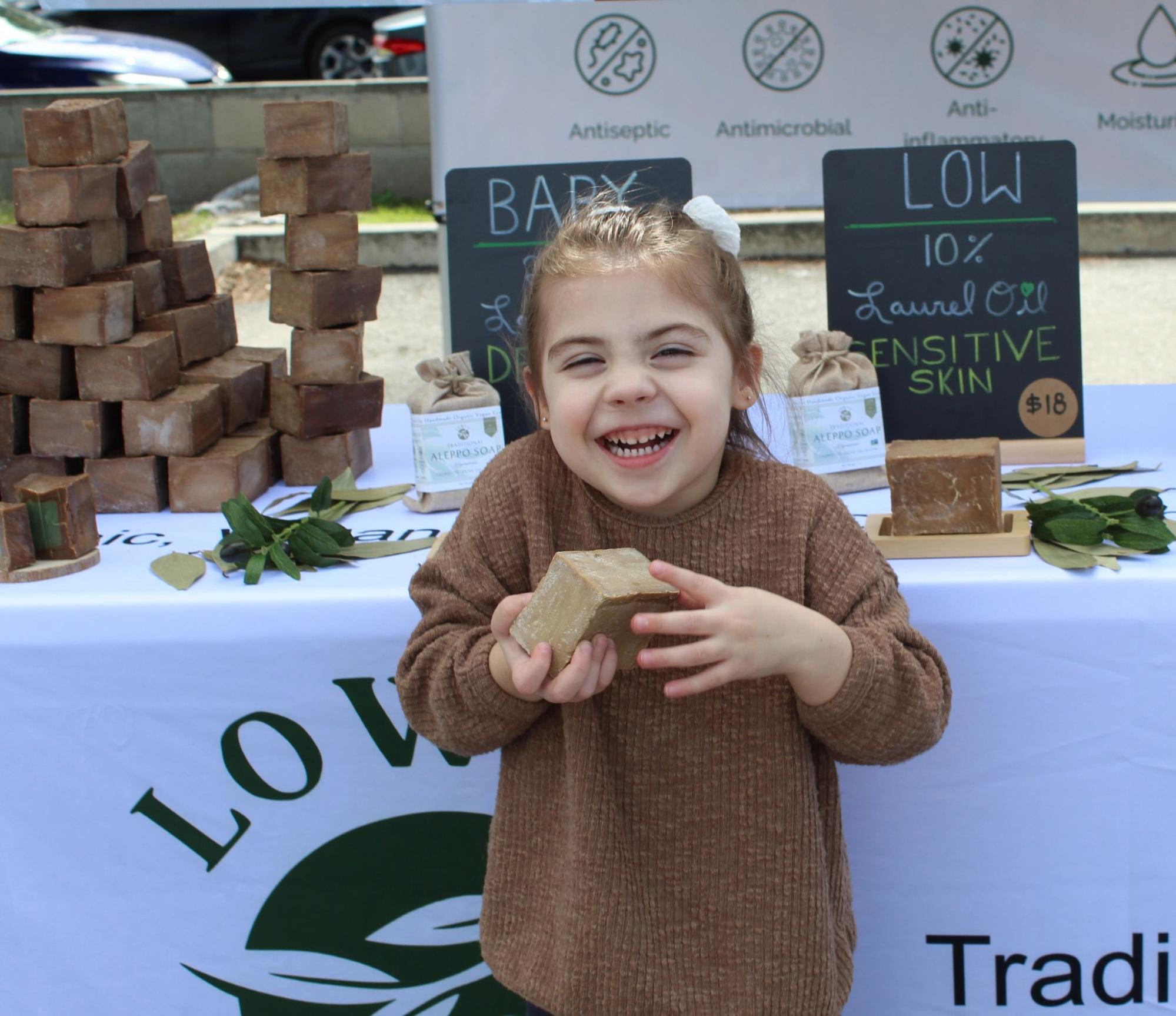 Small white caucasian girl holding aleppo soap bar