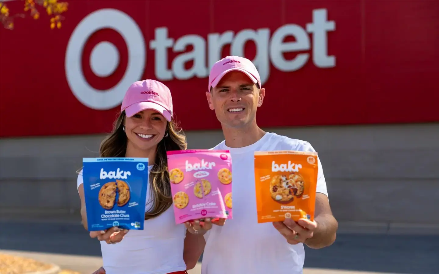 Bakr founder and her husband stand in front of Target holding bags of cookie dough.