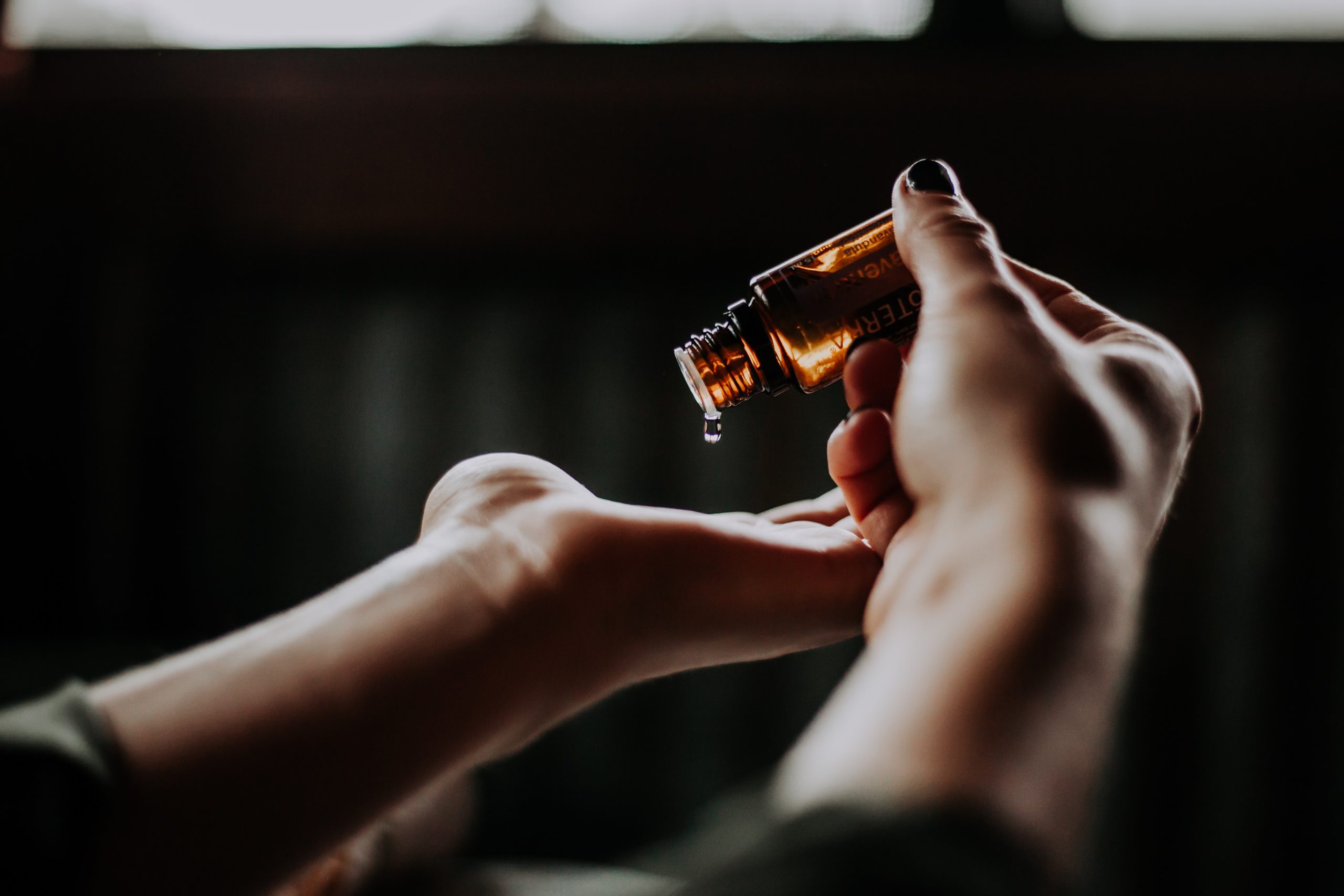 Pouring essential oil on hands