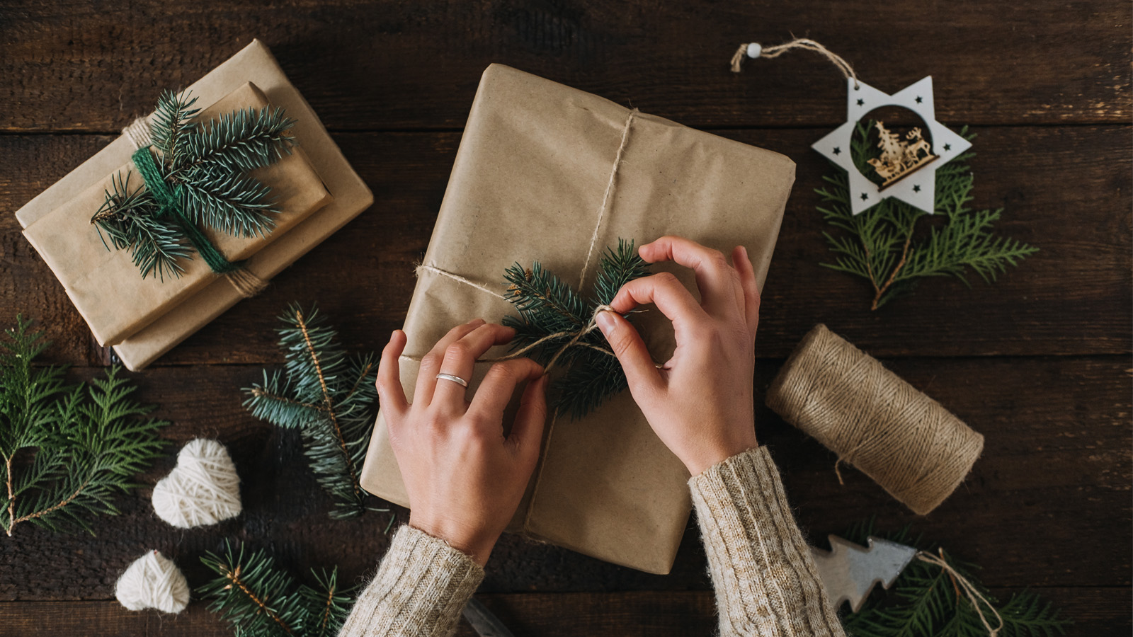 Two hands gift wrapping for the holidays