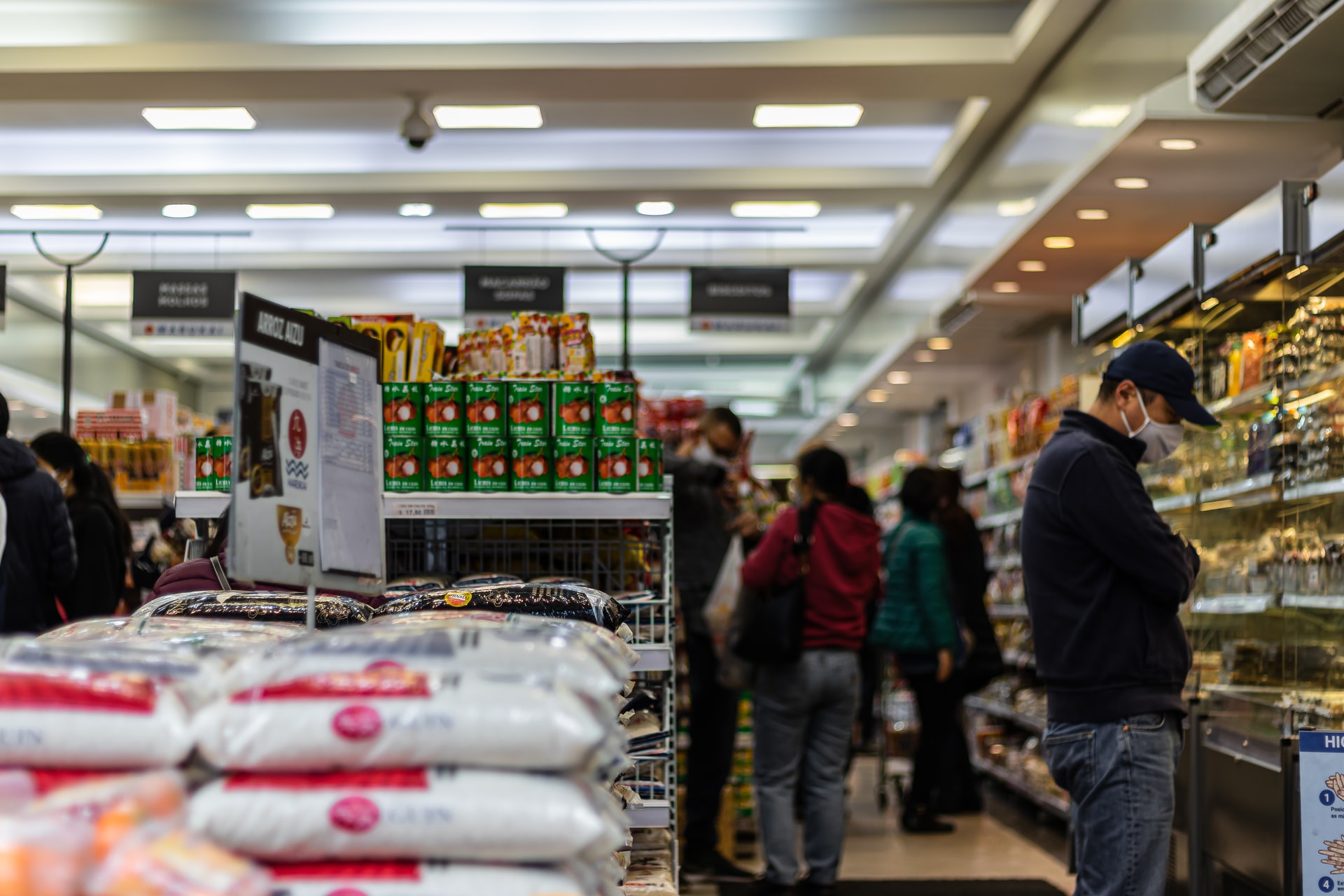 Shoppers inside a supermarket standing in the produce aisle