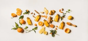 Fresh orange juice with a piece of ginger on a clean white background