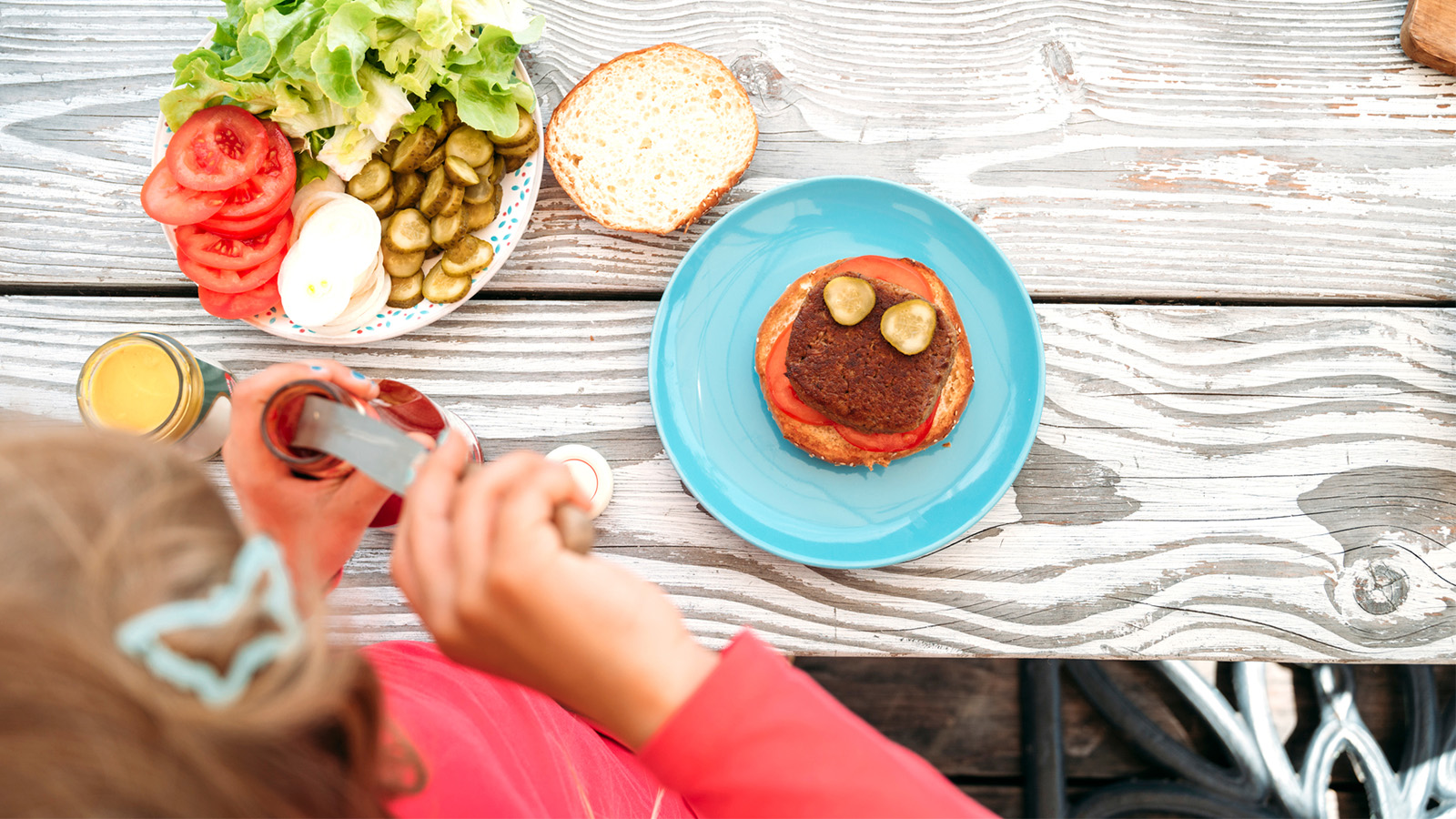 Girl preparing a plant-based burger with love, patty is vegan, no cheese