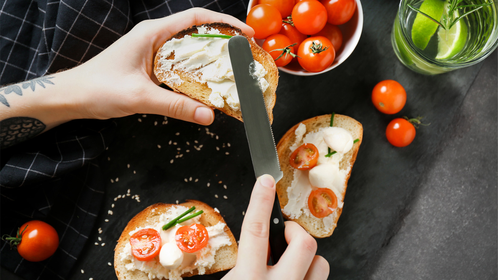 Hands spreading cream cheese on toast